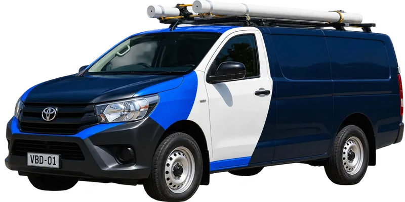 A licensed the Sydney CBD plumbing van loaded with pipe on the roof rack